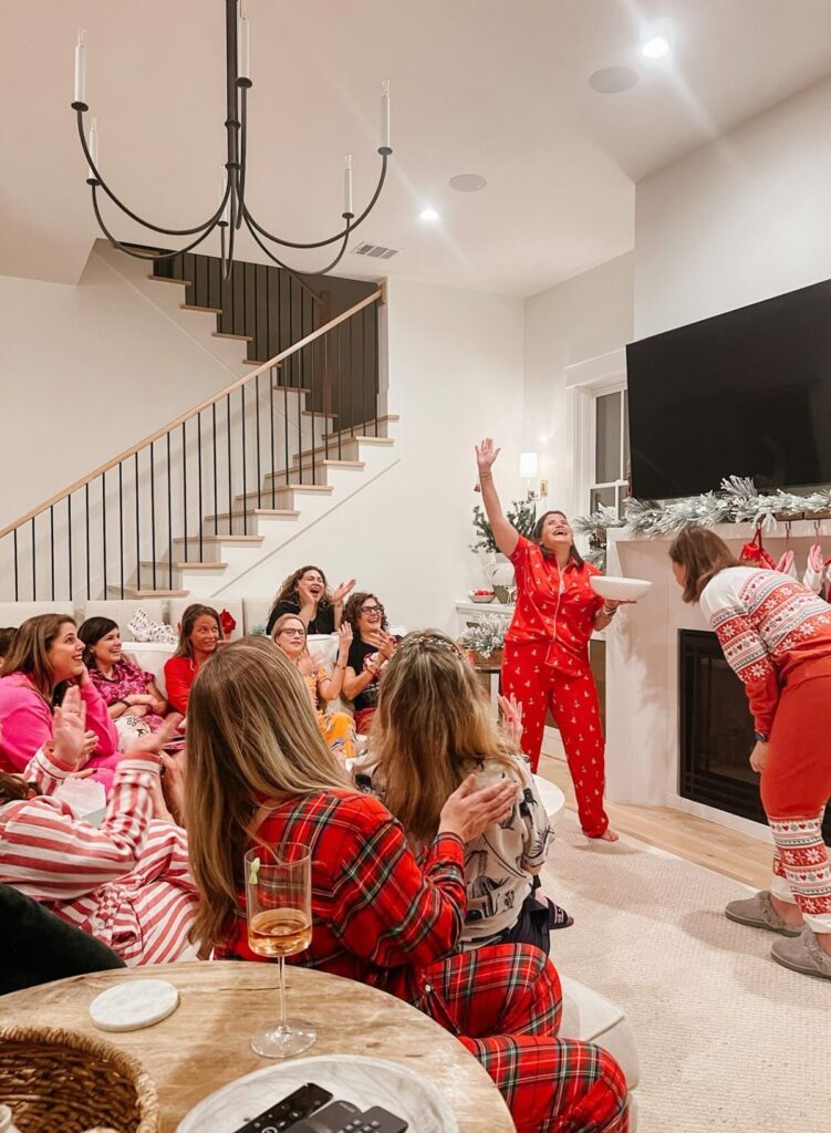 People playing Christmas Charades game, one of the best Christmas party games for adults and kids at a holiday celebration